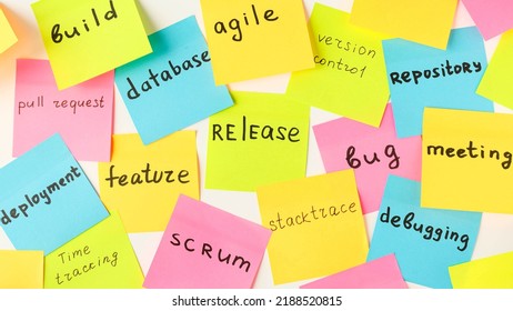 Multi-colored square stickers with terms from the IT field - release, bug, meeting, feature, database, agile