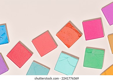 Multi  colored square swatches eyeshadows for makeup beige background  trend pastel vivid colors textures powder for eye cosmetics  eyeshadow color palette  top view  close up pattern  copy space