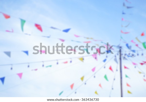 multicolored summer bunting flags hanging at the\
garden, Always have in a carnival and Make the fete feel more fun.\
Blur