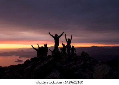 Multi-colored sunset. Silhouettes of people on top of a mountain overlooking the sea. - Shutterstock ID 1429622180