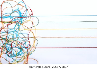Multicolored tangled knitting threads on a white background