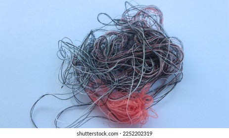 Multi-colored tangled threads abstract texture pattern background. Macro shot of colorful needlecraft silk thread ropes. Colored natural thread pile for sewing clothe scattered randomly like spaghetti