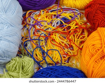 Multi-colored threads for knitting in a tangled state and skeins of yarn, background