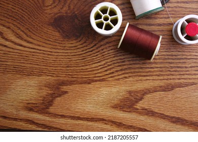 Multicolored threads and old scissors scattered on a wooden table, retro scissors, flat lay, copy space. - Shutterstock ID 2187205557
