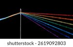 multi-colored threads for sewing in the form of a rainbow pass through an antique needle on a black background close-up