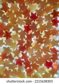 Multi-colored Transparent Jelly Candies In The Shape Of A Star All Over The Background, Brightly Lit From Below. View From Above