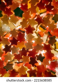 Multi-colored Transparent Jelly Candies In The Shape Of A Star All Over The Background, Brightly Lit From Below. View From Above