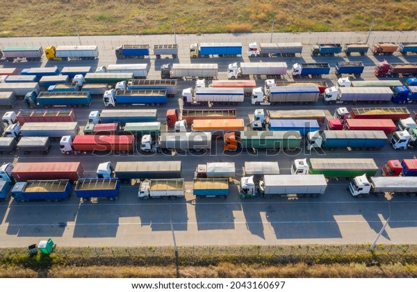 Multicolored trucks\
near the port terminal are waiting to be loaded or unloaded. Modern\
logistics center. Aerial\
view.
