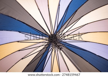 Multicolored umbrella opening, vibrant pattern and symmetry from a low angle
