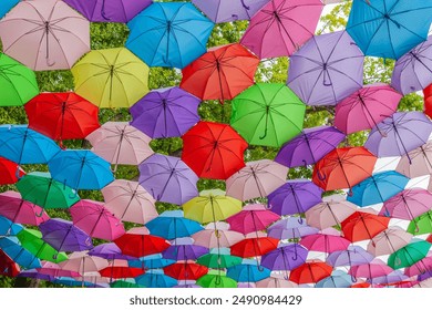 Multi-colored umbrellas background. Colorful umbrellas floating above the street. Street decoration. - Powered by Shutterstock