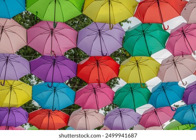 Multi-colored umbrellas background. Colorful umbrellas floating above the street. Street decoration. - Powered by Shutterstock