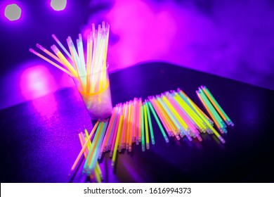 Multicolored UV Fluorescent Sticks In A Glass At A Techno Party