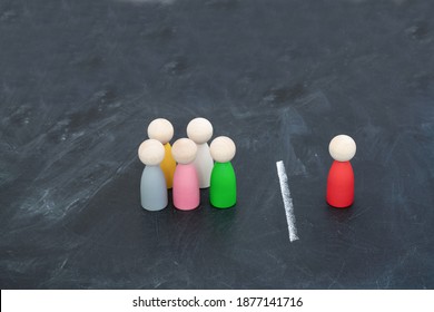 Multi-colored wood figurines illustrating a person or leader addressing a group of people or being isolated because of diversity on black background stock photo - Powered by Shutterstock