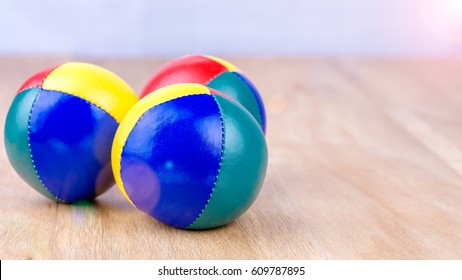 Multi-Coloured Juggle Balls On Wooden Surface