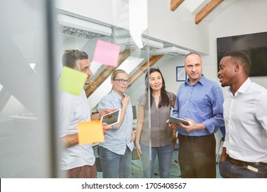 Multicultural business team in a meeting or brainstorming in the office - Shutterstock ID 1705408567