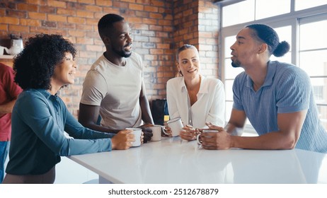 Multi-Cultural Businessmen Taking Coffee Break In Kitchen Area Of Modern Open Plan Office Together - Powered by Shutterstock