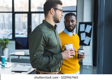 Multicultural Businessmen Talking And Holding Cups Of Coffee