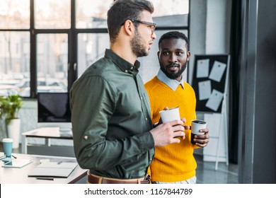 Multicultural Businessmen Talking And Holding Cups Of Coffee