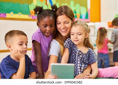Multicultural children and educators have fun making selfies with the tablet computer - Shutterstock ID 1995041582