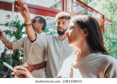 Multicultural colleagues brainstorming ideas and problem-solving in a modern office. They gather around a glass wall adorned with sticky notes, writing and sharing insights for business growth.