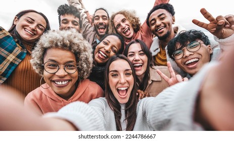 Multicultural community of young people smiling together at camera - Happy diverse friends taking selfie picture with smart mobile phone device - Friendship and human relationship concept - Powered by Shutterstock