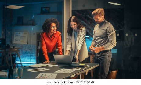 Multicultural Creative Colleagues Casually Joking, Discussing a New Business Opportunity, Talking in an Office Meeting Room, Using a Laptop and Tablet for Brainstorming Corporate Marketing Ideas. - Powered by Shutterstock