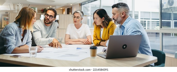 Multicultural designers sharing creative ideas during a meeting in a modern office. Group of innovative businesspeople having a discussion while working on a new project. - Shutterstock ID 2214584391