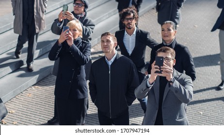 Multicultural Diverse Office Managers And Business People Suddenly Stop On The Street And Look Up. Unbelievable, Fantastic Or Tragic Event Happening Live. Crowd Takes Out Smartphones And Record Video.