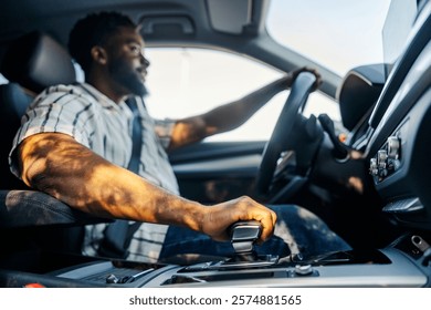 Multicultural driver changing speed in luxury car. Selective focus on hand on transmission lever.