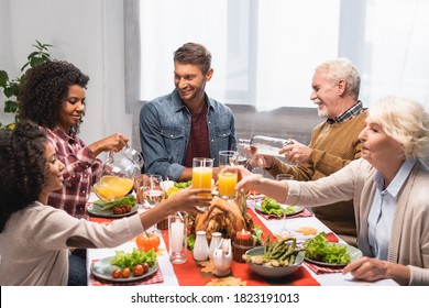 Multicultural Family Clinking Glasses With Beverages During Celebration Of Thanksgiving Day