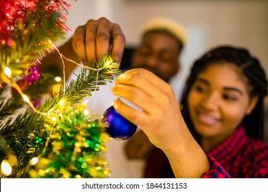 Multicultural Family Decorating Christmas Tree With Ball And Garland