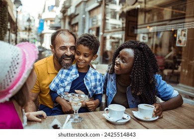 Multicultural Family Enjoying Desserts at an Outdoor Cafe - Powered by Shutterstock