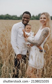 Multicultural Family With One Child On Vacation In Wheat Fields