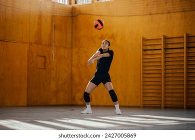 A multicultural female teenage volleyball player is hitting and passing the ball on indoor court during the training. An active sportswoman in action passing the ball on volleyball court on training. - Powered by Shutterstock