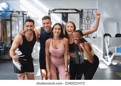 multicultural fitness group posing and smiling looking at the camera in the gym - Powered by Shutterstock