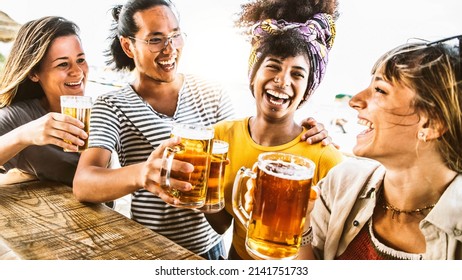 Multicultural Friends Cheering Beer Glasses Together Outside - Happy Young People Celebrating Summertime In Open Brewery Pub - Beverage Event And Happy Lifestyle Concept