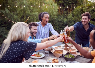 Multi-Cultural Friends At Home Around Table Making A Toast As They Enjoy Food At Summer Garden Party - Powered by Shutterstock