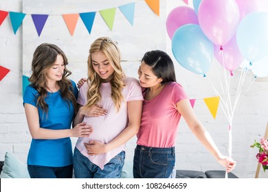 multicultural friends and pregnant woman touching belly at baby-party - Powered by Shutterstock