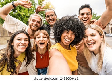 Multicultural friends smiling at camera together outside - Happy young people taking selfie with smart mobile phone device walking on city street - Youth community and technology concept - Powered by Shutterstock