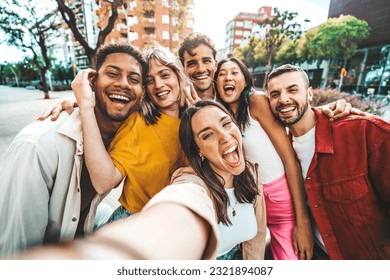 Multicultural friends taking selfie pic with cellphone outside - Happy young people having fun hanging out on city street - Summer vacation concept with guys and girls enjoying summertime holiday - Powered by Shutterstock