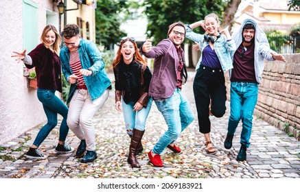Multicultural friends walking at old town acting crazy funny moves - Happy men and women having fun on city street with party travel mood - College students at university campus on bright vivid filter