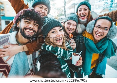 Multicultural friends wearing winter clothes enjoying winter vacation together - Happy young people celebrating new year eve - Friendship and winter holidays concept