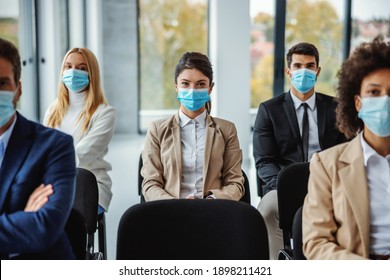 Multicultural Group Of Business People With Face Masks Sitting On Seminar During Corona Virus.