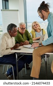 A Multicultural Group Of Elderly Students Listening To An Explanation From A Young Teacher In The Classroom.