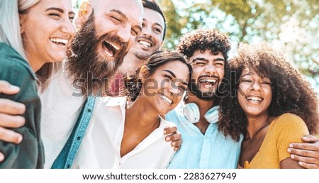 Multicultural group of friends enjoying summertime vacation hanging outside together - University students having fun in college campus - Life style concept with guys and girls laughing together