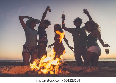 Multicultural group of friends partying on the beach - Young people celebrating during summer vacation, summertime and holidays concepts