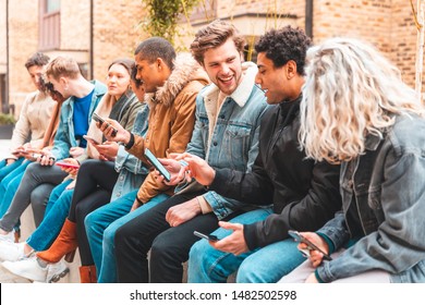 Multicultural group of friends using smartphone and having fun - Happy group of multiracial people addicted to smart phones and social media - Technology concept and millennials lifestyle
