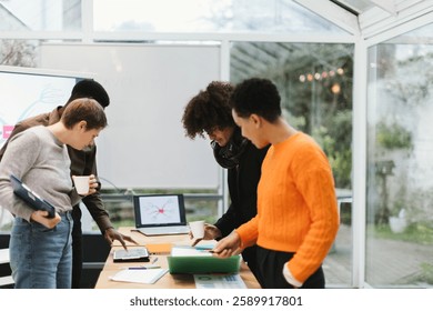 multicultural group of professionals working together at a table, reviewing documents and using digital devices in a modern office setting
