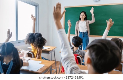 Multicultural group of students raising hands in class on lecture education, elementary school, learning people concept. Group team work of school kids with teacher sit in classroom and raising hands - Powered by Shutterstock