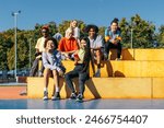 Multicultural group of young friends bonding outdoors and having fun - Stylish cool teens gathering at urban skate park